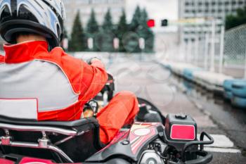 Karting racer, go kart driver in helmet, back view. Carting speed track 