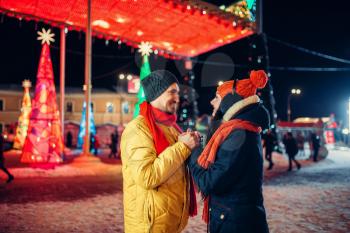 Evening winter walk, love couple on the square. Man and woman having romantic meeting on city street with lights