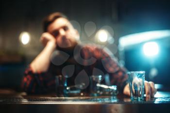 Drunk man sleeps at the bar counter, alcohol addiction. Male person in pub, alcoholism