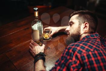 Drunk man sleeps at the bar counter, top view, alcohol addiction. Male person in pub, alcoholism