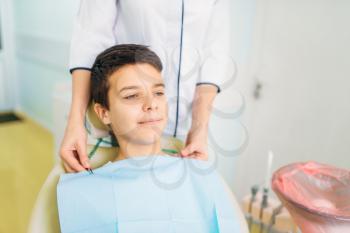 Boy in a dental chair, pediatric dentistry. The doctor examines the teeth of a small patient