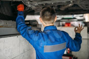 Repairman adjusts the wheel angles of the car on stand in auto-service. Computer diagnostic of vehicle suspension, collapse of convergence