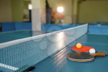 Two ping pong rackets and balls on game table with net, nobody, closeup view. Table-tennis club, tennis concept, ping-pong