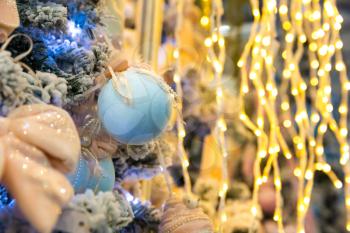 Christmas tree decorated with blue balls and lights, garland closeup. Xmas decor, new year. Winter holiday celebration
