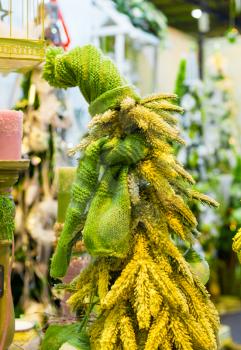 Christmas tree decorated with green hat and scarf. Xmas decoration, new year. Winter holiday celebration