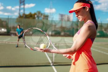 Couple playing tennis on outdoor court. Summer season active sport game