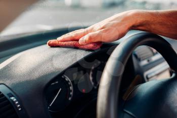 Male hands cleans auto, car dashboard polishing on carwash station. Man rubbing vehicle torpedo with polish.