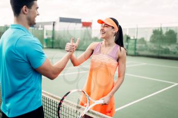Man and woman partners on outdoor tennis court. Summer season active sport game