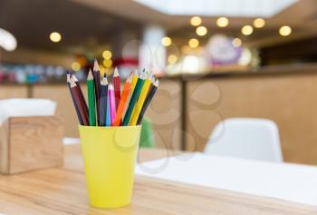 Colorful pencils in yellow glass closeup. Fine art concept