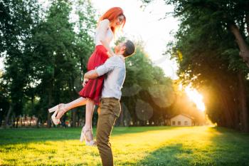 Romantic date, embracing of love couple, meeting in summer park. Attractive woman and young man happy together