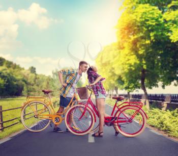 Young man and woman, romantic date on bicycles. Happy love couple with vintage bikes kissing in park. Boyfriend and girlfriend together outdoor, retro cycle