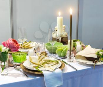 Romantic dinner, table with decoration, nobody. Candles, plates with ears of wheat decor