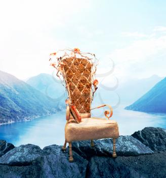 Old chair with grunge upholstery, mountains and lake on background. Classic luxury style. Abstract decoration