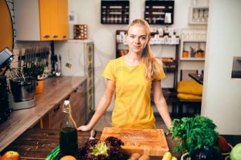 Young woman cooking on the kitchen, healthy food. Vegetarian diet, fresh vegetables and fruits