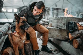 Stalker, post-apocalypse soldier feeding a dog. Post apocalyptic lifestyle on ruins, doomsday, judgment day