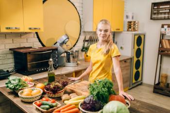 Young woman cooking on the kitchen, healthy food. Vegetarian diet, fresh vegetables and fruits