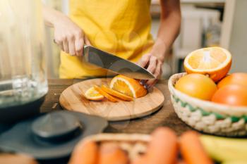 Housewife cooking orange juice, organic food. Vegetarian diet, healthy lifestyle concept