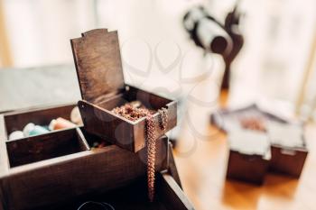 Needlework accessories, little metal rings in wooden box on the table, closeup, selective focuse, nobody. Handmade jewelry, bijouterie making