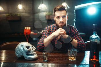 Sad man sitting at the bar counter, alcohol addiction, depression. Male person in pub, alcoholism