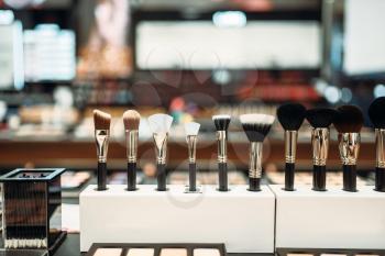 Cosmetic collection, brushes in makeup shop closeup, nobody. Make-up products on showcase in store