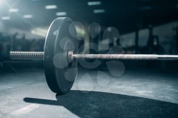 Barbell on the floor in gym closeup view, nobody. Weightlifting sport concept, heavy weights