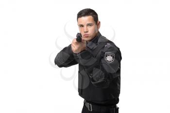 Armed police officer aims with a gun, black uniform with body armor, white background, front view. Policeman in special ammunition