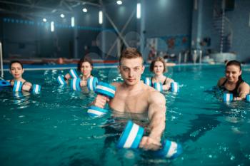 Trainer and female aqua aerobics group, exercise with dumbbells on training in swimming pool. Fitness workout, water sport 