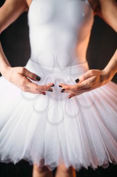 Classical ballet dancer body in white dress, black background. Slim ballerina poses