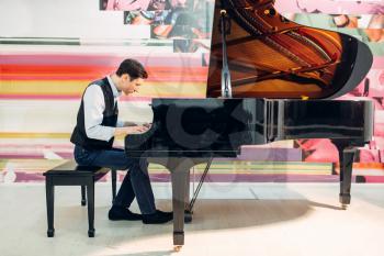 Male pianist practicing composition on grand piano. Musician plays melody at the royale, classical musical instrument