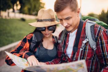 Couple of tourists looking for city attractions on the map, excursion in  town. Summer hiking. Hike adventure of young man and woman