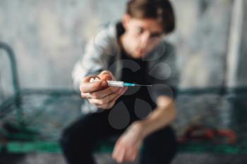Male junkie reaching out hand with syringe. Drug addiction concept, addicted people