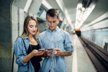 Phone addict couple using gadget in subway, addiction problem, social addicted people, modern lifestyle