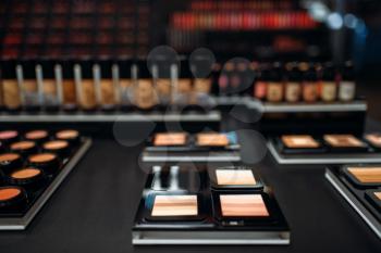 Powders collection, showcase in beauty shop closeup, nobody. Makeup products in the store, cosmetic department