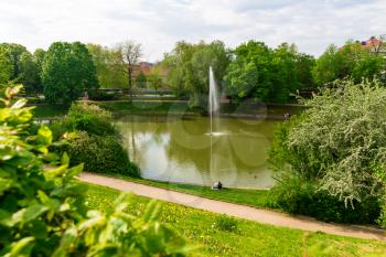 Park with a pond in old European town. Summer tourism and travels, famous europe landmark, popular places and streets