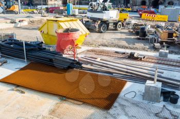 Construction site in the middle of the old european city. Concrete mixer and reinforcement mesh in downtown, building engineering