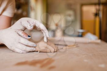 Female potter hands covered with dried clay, pottery workshop. Woman molding a bowl. Handmade ceramic art, tableware making