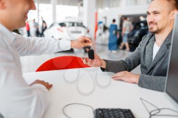 Manager gives to buyer key, new car in showroom. Male customer buying vehicle in dealership, automobile sale, auto purchase