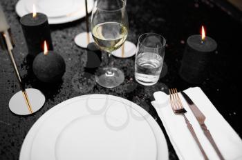 Table setting, luxury silverware and tableware on black closeup, nobody. Elegant decoration. Romantic celebration on summer meadow