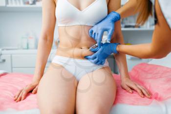 Cosmetician hands in gloves gives botox injection in the stomach to female patient on treatment table. Rejuvenation procedure in beautician salon. Doctor and woman, cosmetic surgery against wrinkles