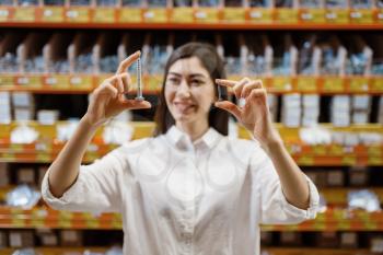Female customer choosing tapping screw in hardware store. Buyer look at the goods in diy shop, shopping in building supermarket