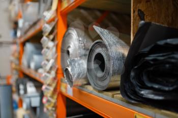 Rolls of thermal insulation in hardware store closeup view, nobody. Materials for building and repairing on the shelf in diy