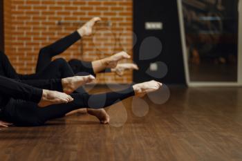 Female contemporary dance performers, legs flexibility, stretching exercise, women in studio. Dancers training in class, modern ballet, elegance dancing