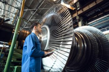 Male engineer checks turbine impeller vanes on factory. Industrial production, metalwork engineering, machines manufacturing