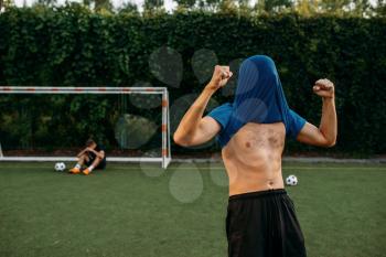 Male soccer player hits the goal on the field. Footballers on outdoor stadium, workout before game, football training