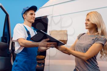 Deliveryman in uniform gives parcel to female customer at the car, delivery service. Man holding cardboard package near the vehicle, male deliver and woman, courier or shipping job