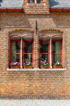 Ancient building facade with flower bed on window, old European town. Summer tourism and travels, famous europe landmark, popular places for travelling