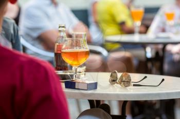 Tourists drinks beer in street cafe in old European tourist town. Summer tourism and travels, famous europe landmark, popular places for travelling