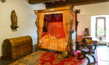 Luxury bed with canopy in old castle, ancient stone building interior, Europe. Traditional european architecture, famous places for tourism and travel