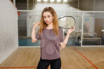 Female player holds squash racket and ball. Girl on game training, active sport hobby on court