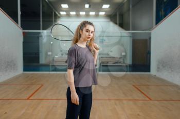 Female player poses with squash racket on court. Girl on game training, active sport hobby, fit workout for healthy lifestyle